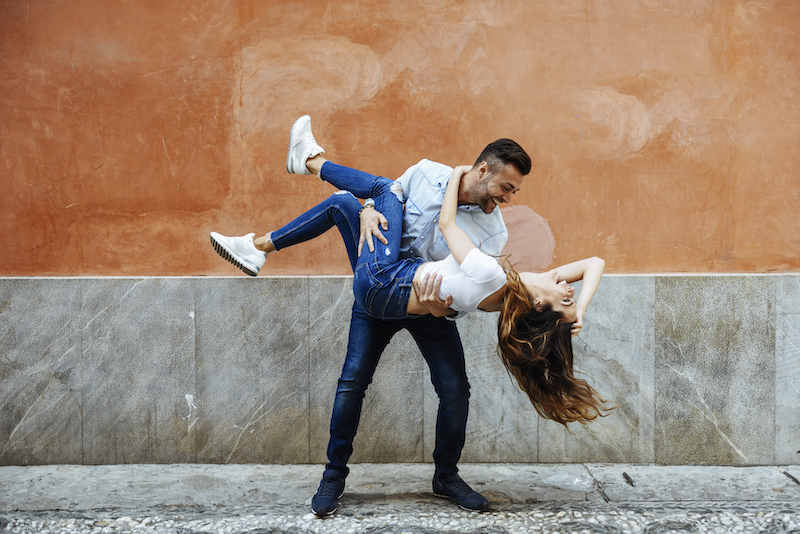 Carefree couple in love in front of a wall outdoors