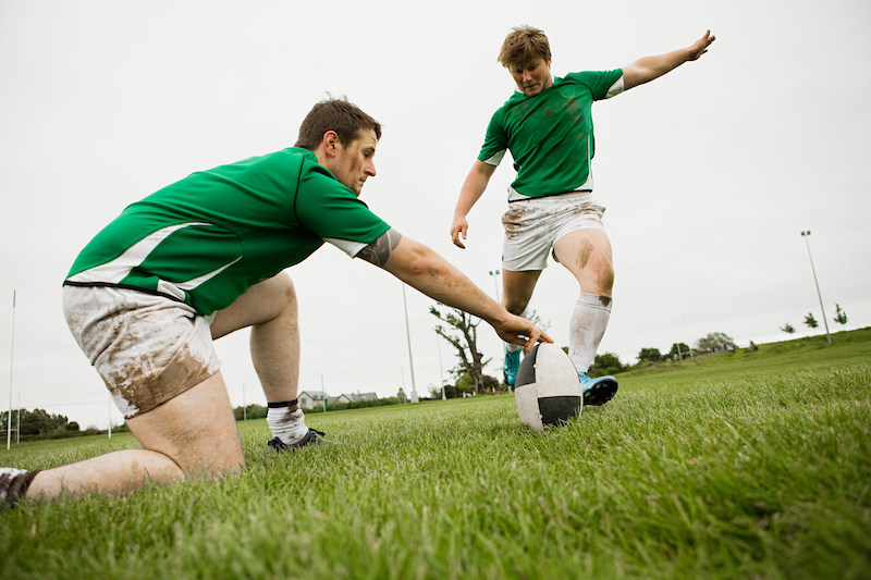 Rugby player kicking ball