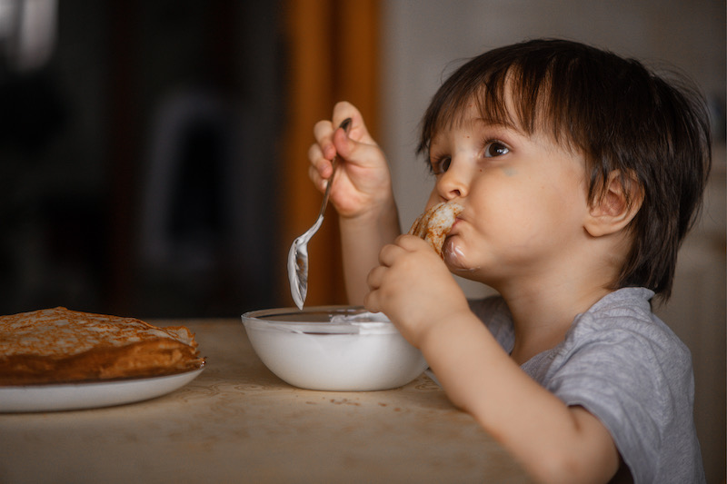 child eating pancakes