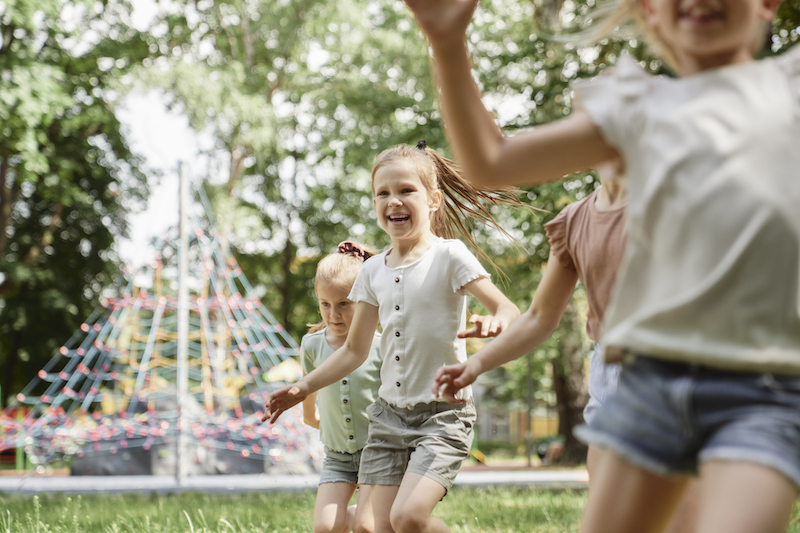 Group of kids playing at the playground in summer day