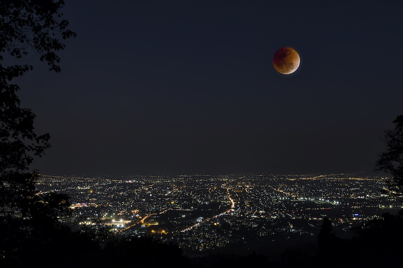Lunar eclipse over Chiang Mai city. Blood Moon in the lunar eclipse and also a Blue Moon and super moon called Super Blue Blood Moon