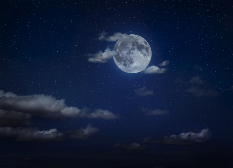 Moon and clouds in the night. Moonlight background. Dark blue backdrop.