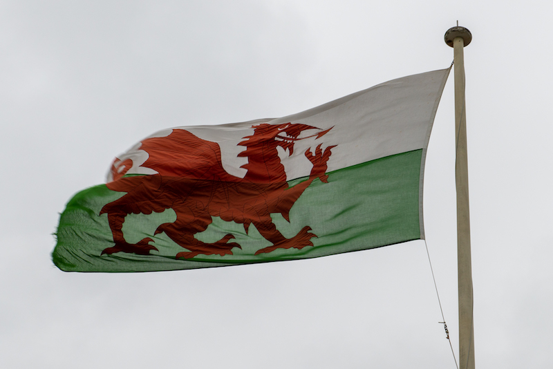 A beautiful shot of a flag of Wales under the cloudy skies