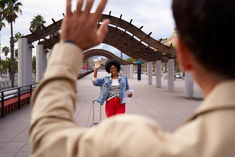 woman with a suitcase saying goodbye to her boyfriend