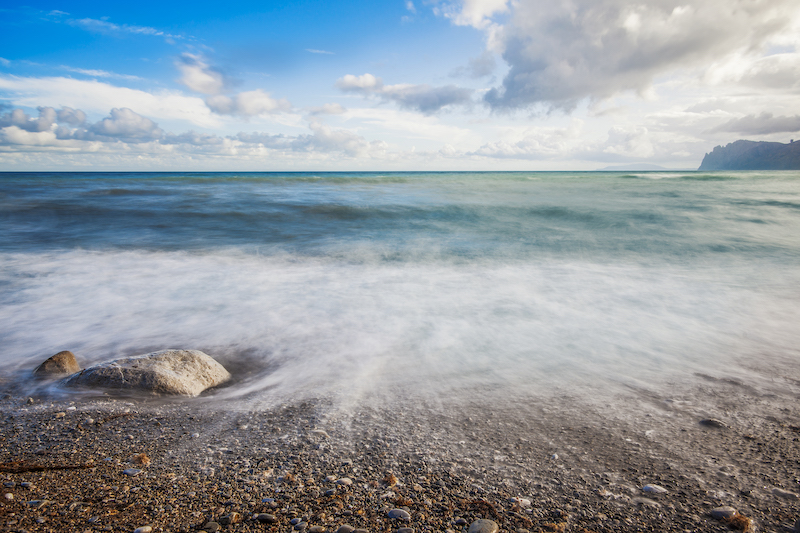 Sandy beach with mountains in the background.