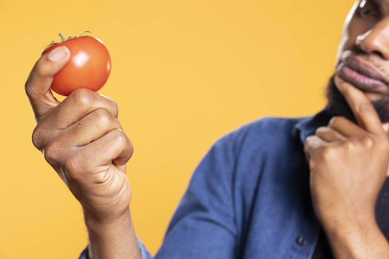 Man admiring ripe tomato