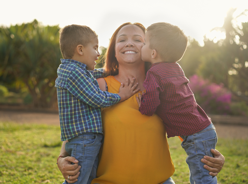 happy mother at the park with her twin boys