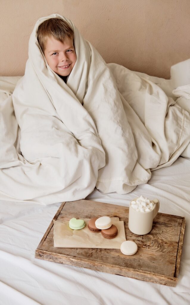 boy wrapped in white blanket