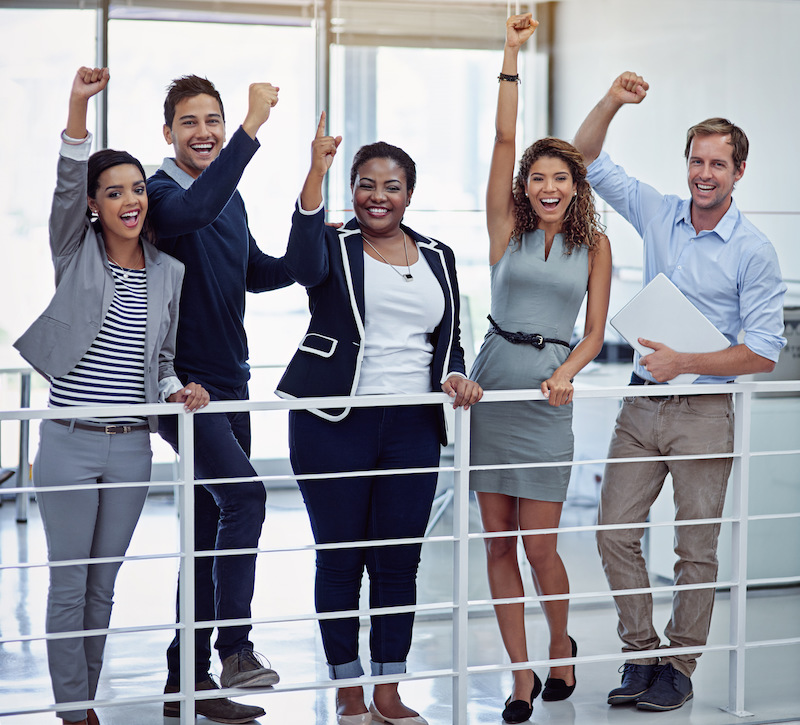 Portrait of a group of colleagues celebrating together in an office.