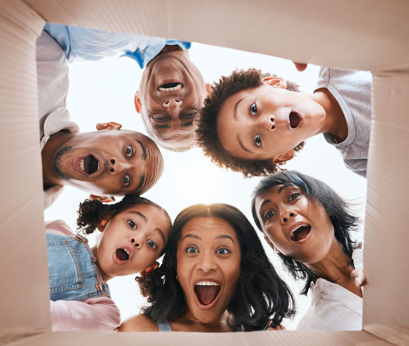 Family, open box and surprise from below with smile, portrait and circle for present, together and .