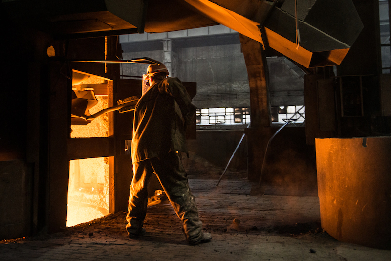 Steelworker at work near the working arc furnace
