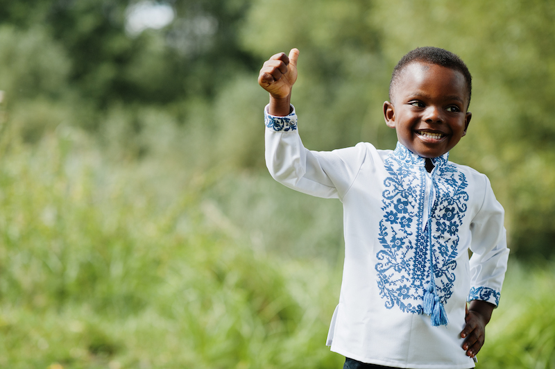 Portrait of african boy kid in traditional clothes at park.