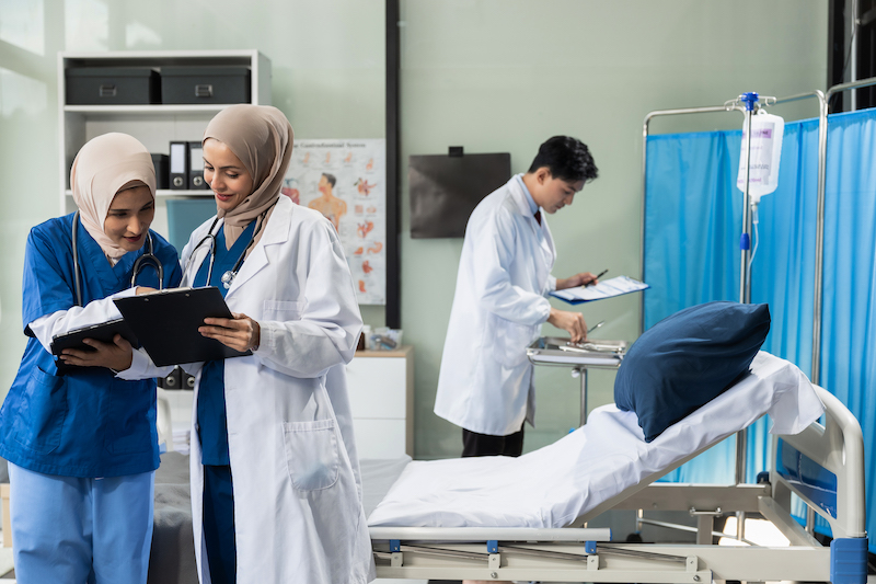 Doctors working together on laptop computer and tablet and medical stethoscope on clipboard on desk, electronics medical record system EMRs concept