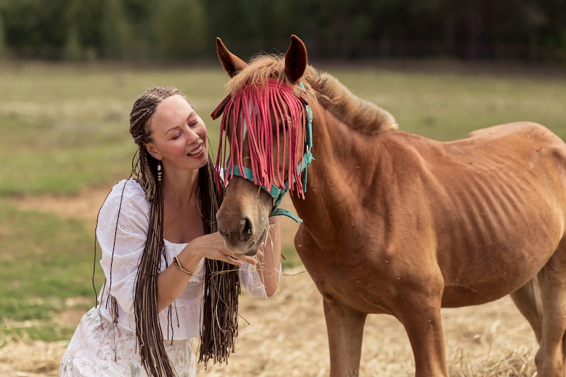 woman taking care of a horse