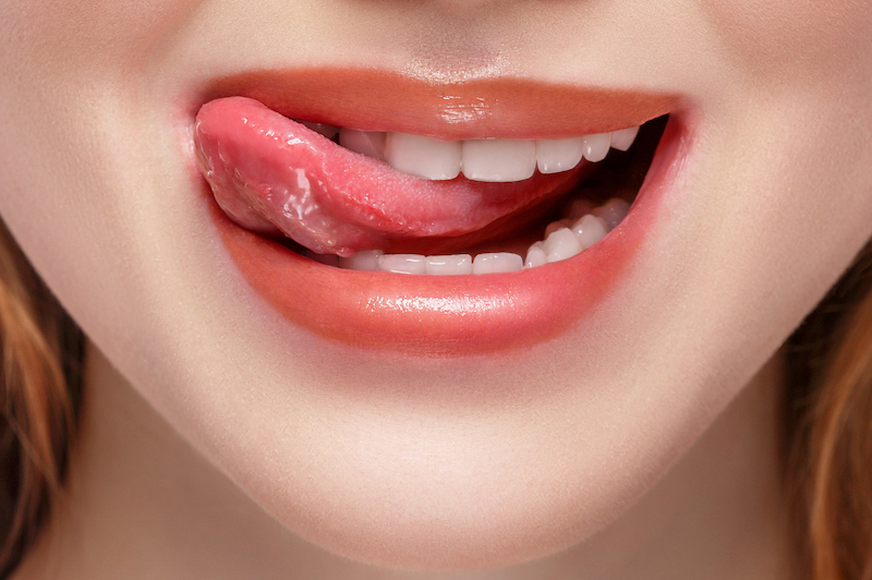 woman licking her teeth with tongue