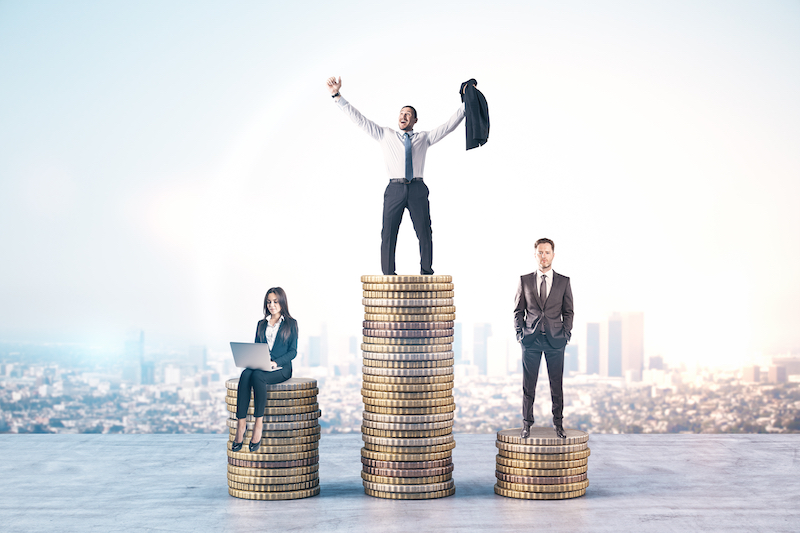 happy business people standing on stacks of coins