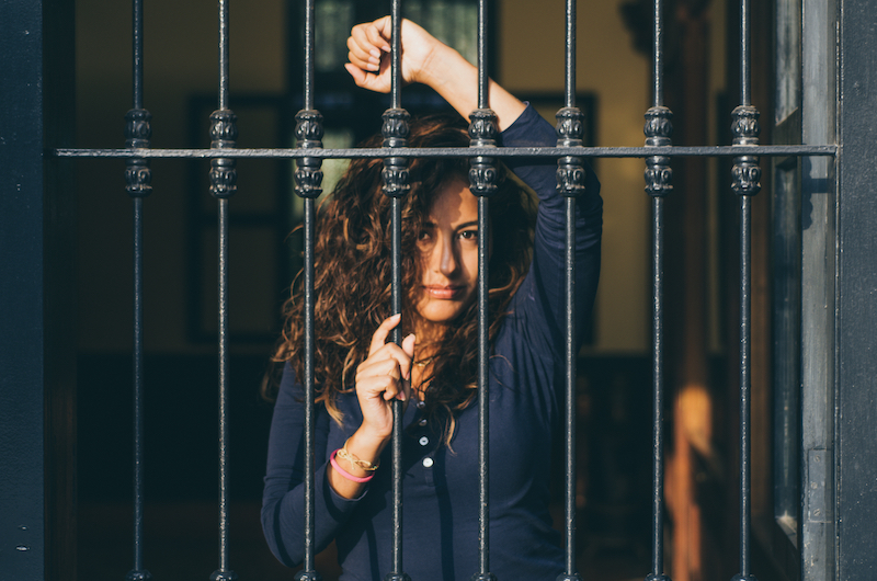 a young woman behind bars