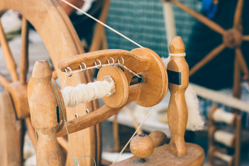 Close up of the detail of a wooden vintage spinning wheel during an exhibition in a medieval fair