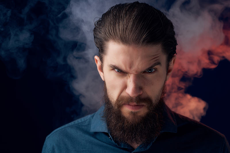 handsome man in a black shirt smoke clouds isolated background