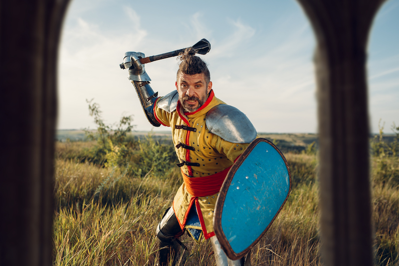 Medieval knight poses in armor opposite the castle, great tournament.